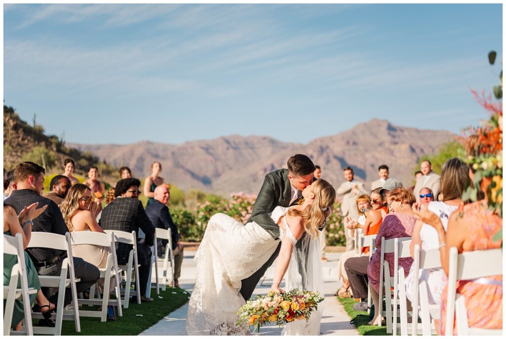 groom dipping back the bride after walking back down the aisle in Arizona