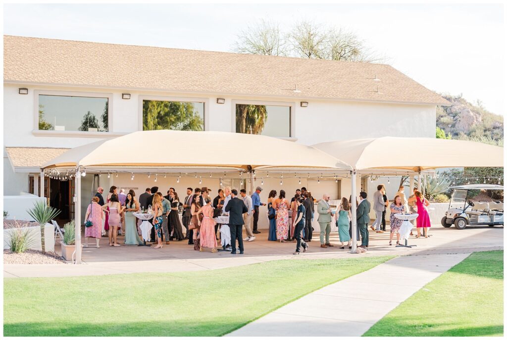 wedding guests mingling at cocktail hour under a big tent in Gold Canyon, Arizona wedding venue