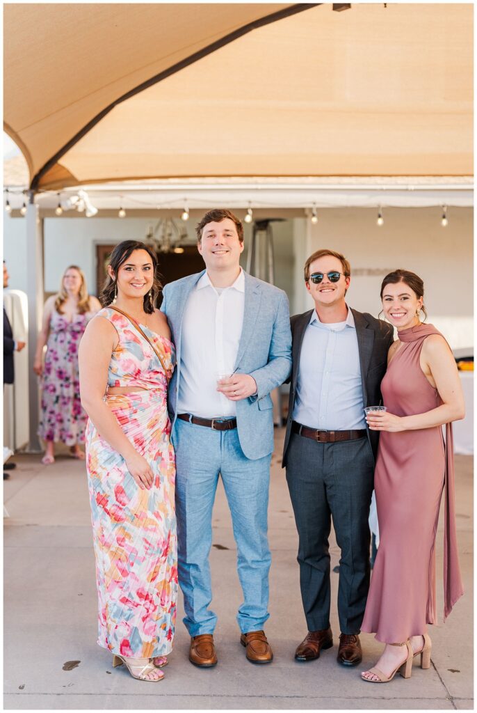 wedding guests posing during cocktail hour under a big tent in Gold Canyon, Arizona wedding venue