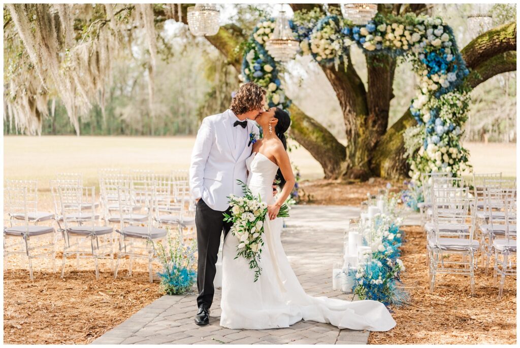 bride and groom share a kiss at the end of the altar in Bluffton, SC