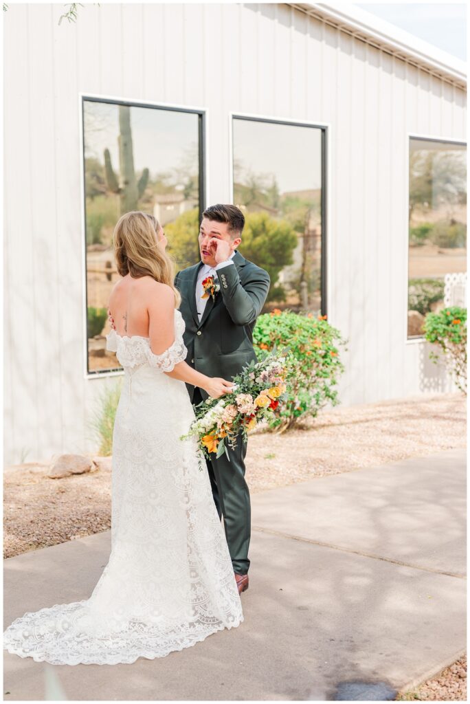 groom crying while seeing the bride during their first look outside at AZ wedding venue