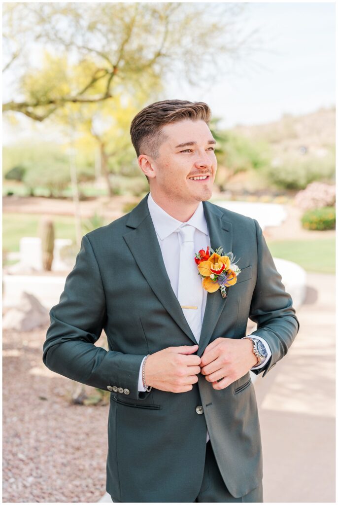 groom buttoning his suit jacket before the first look outside at Gold Canyon, AZ venue