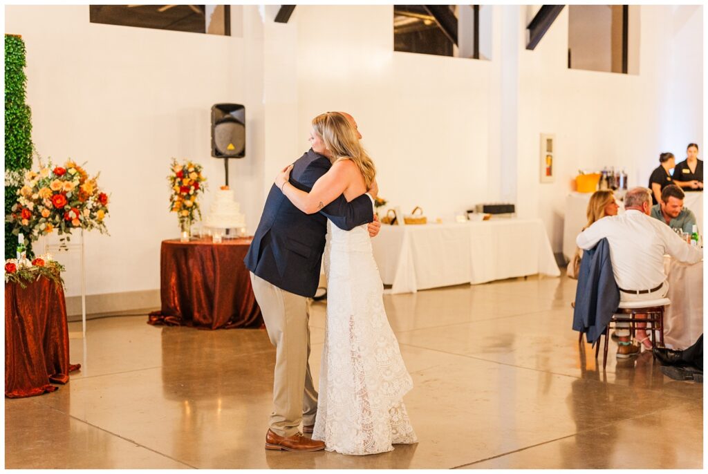 bride hugging her dad after dancing with him inside at the reception at Gold Canyon resort venue