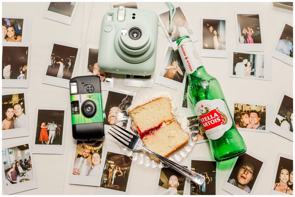 cameras, cake and a beer bottle sitting on top of photos at the end of the wedding