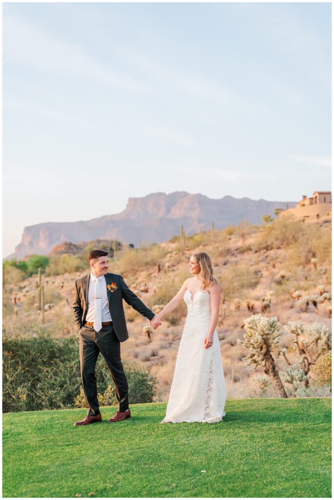 groom holding hands with the bride along the golf course in Arizona