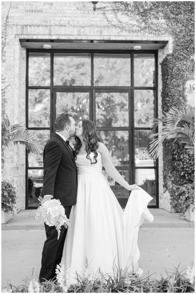 Wilmington wedding photographer taking portraits of the bride and groom sharing a kiss outside 