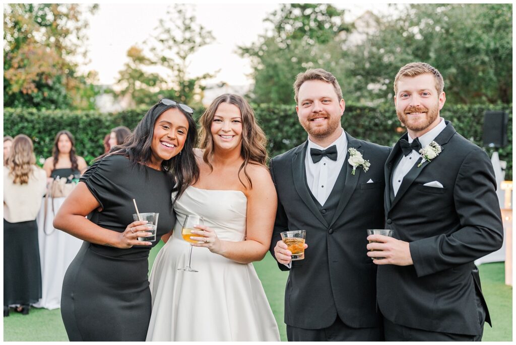 wedding couple posing with guests during cocktail hour