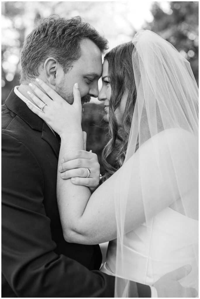 bride and groom touching noses and holding each other during golden hour