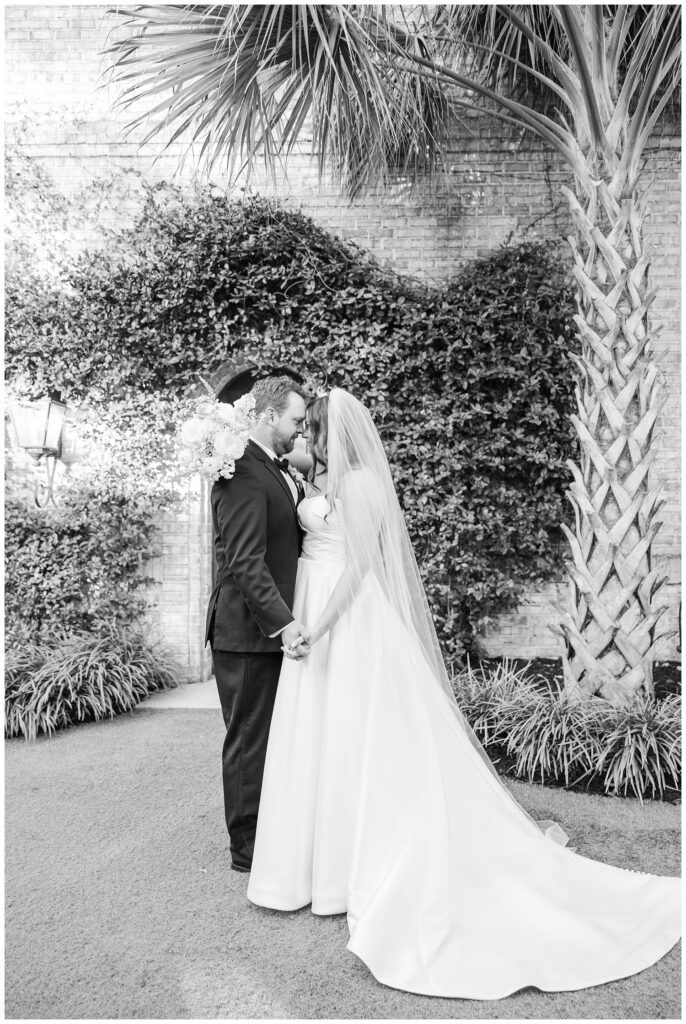 couple posing in front of the palm tree during golden hour at Wilmington wedding venue