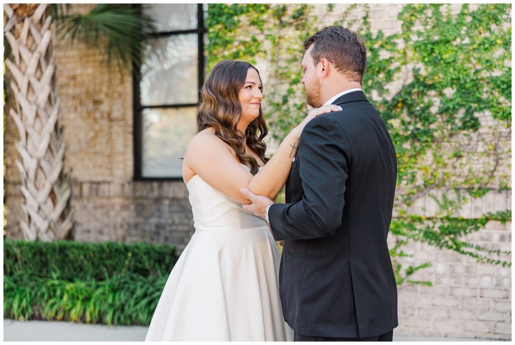 first look between the bride and her dad outside in front of large windows in Wilmington