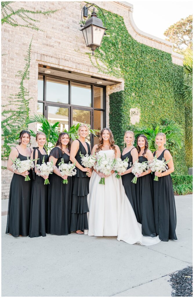 bride posing with her bridesmaids outside at Wrightsville Manor