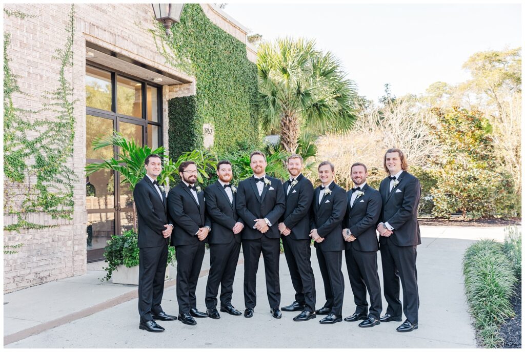 groom posing with his groomsmen outside in front of the venue in Wilmington 