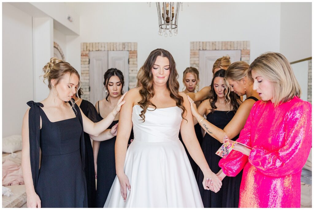 bridesmaids praying over the bride before the ceremony at Wrightsville Manor