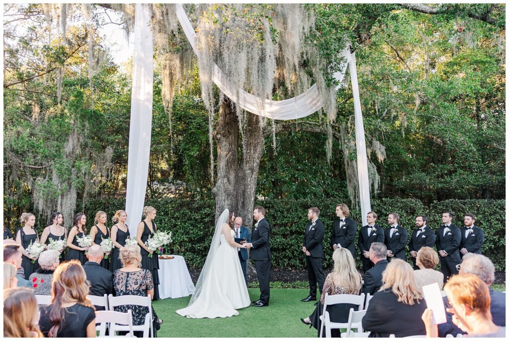 bride and groom holding hands during the ceremony at Wrightsville Manor wedding venue