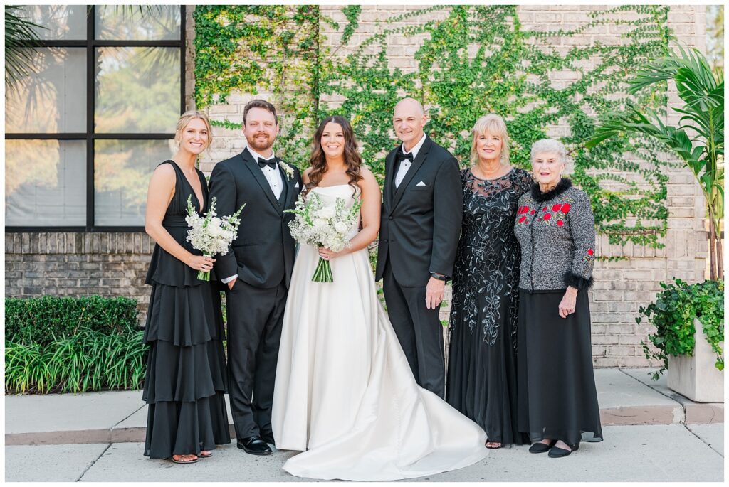 bride and groom posing with family before the ceremony with Wilmington wedding photographer