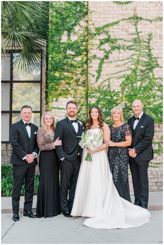 bride and groom posing with family before the ceremony with Wilmington wedding photographer
