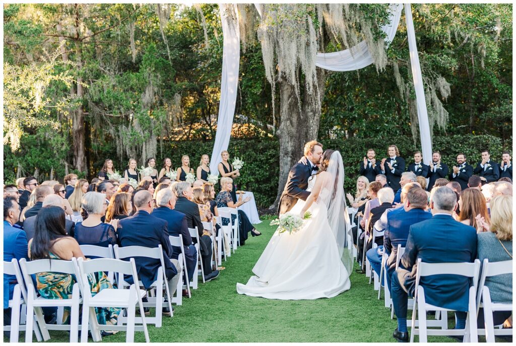 groom dipping the bride back for a kiss while walking back down the aisle in Wilmington