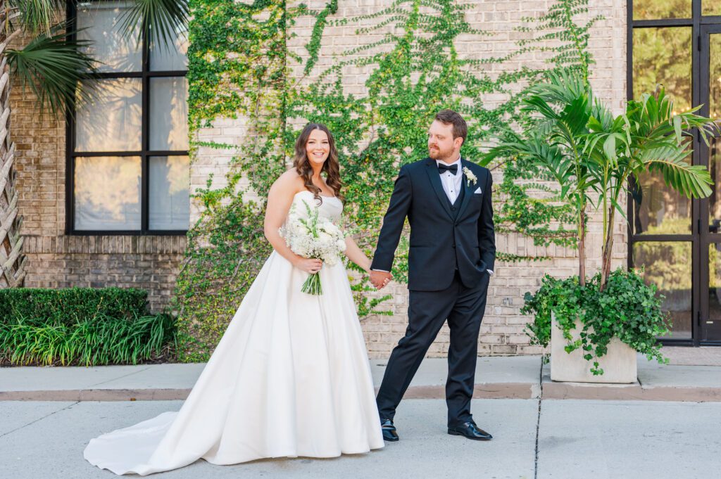 wedding couple walking hand in hand in front of Wrightsville Manor