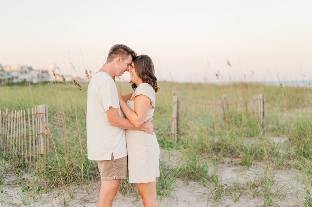 engaged couple posing on the beach in Wilmington at sunset