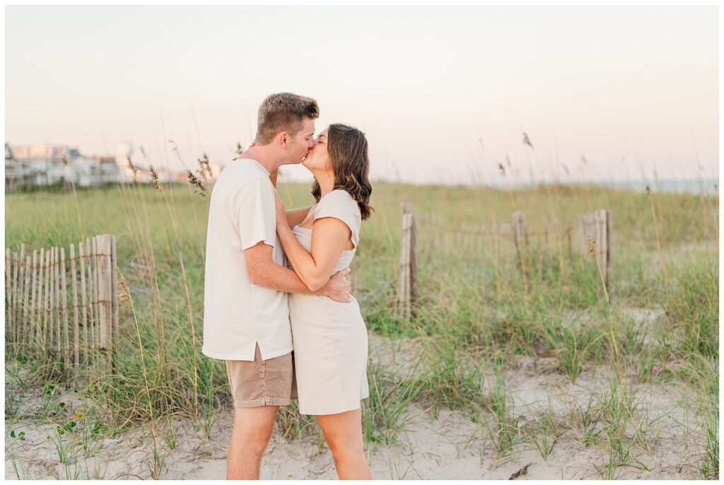 couple kissing on the sand during sunset at Wrightsville Beach in Wilmington