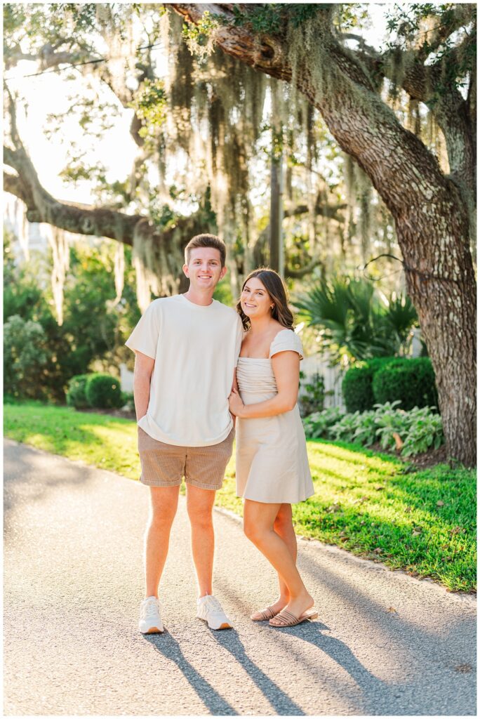 couple posing under a live oak tree for Wilmington engagement session