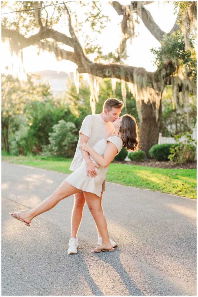 fiance dipping back his girlfriend for a kiss in the road for Wilmington engagement portraits 